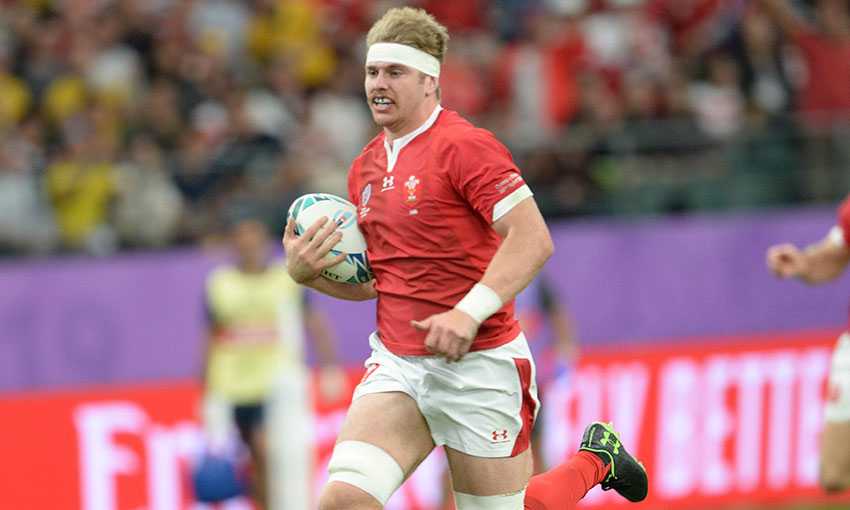 Wales rugby player Aaron Wainright runs holding a rugby ball during an international match