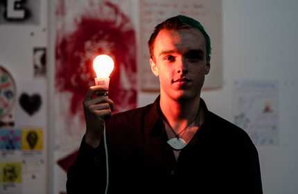 Student holds glowing lightbulb in hand