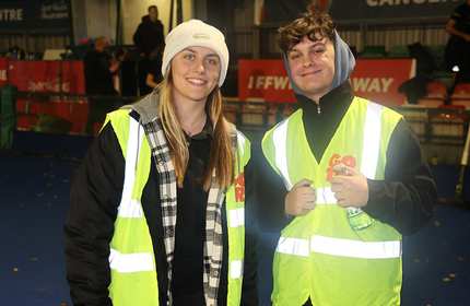 Jack Morgan stands with a woman, both of whom are wearing high-visibility jackets