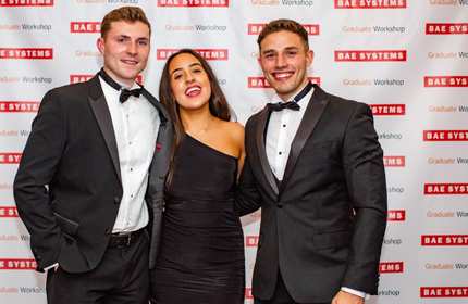 Kieran Bevan and two others wearing black tie event clothing stand for a photograph