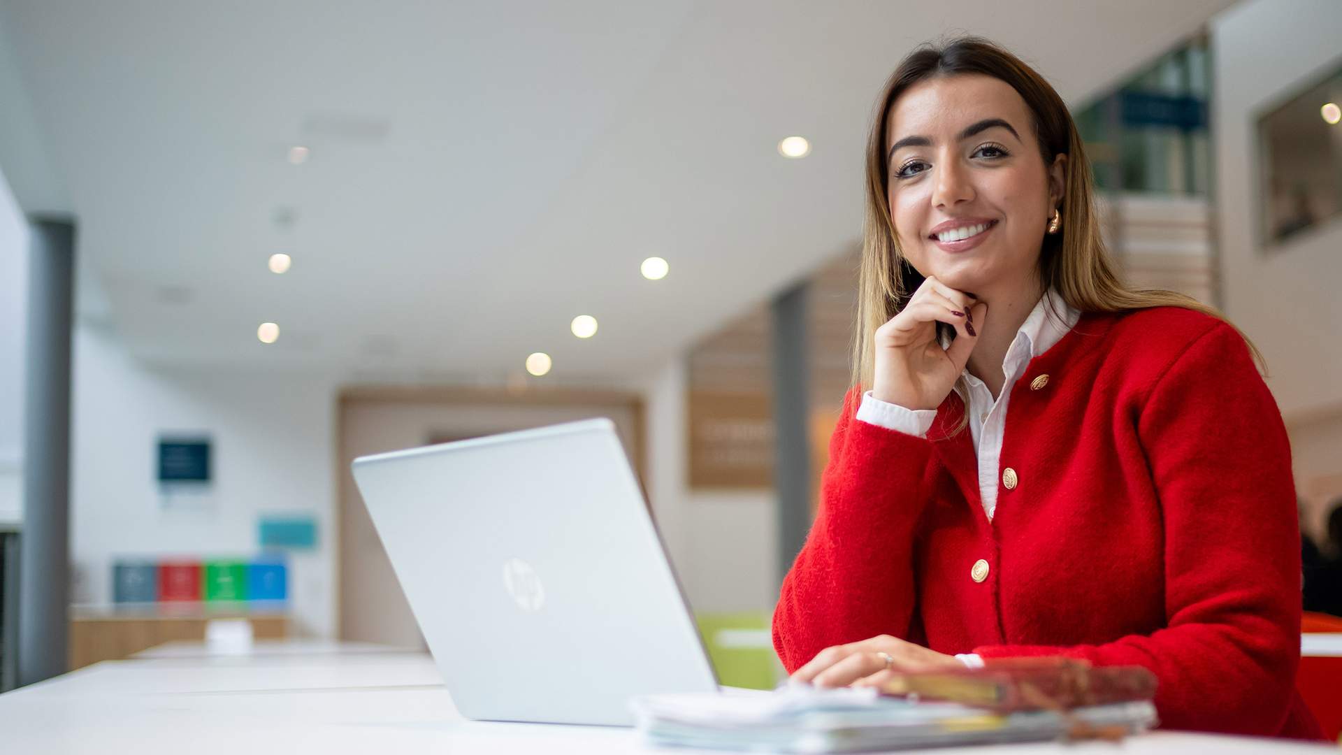A person with dark hair sits in a chair, looking at a large computer monitor displaying various graphs and data in a financial analysis program.