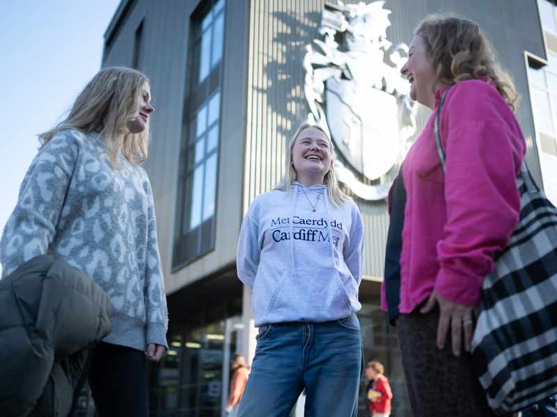 Student holding a Campus Tours Sign
