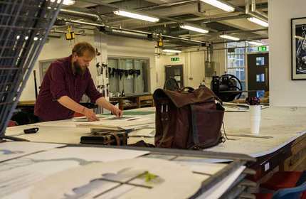 Student works on an art project on a large works table