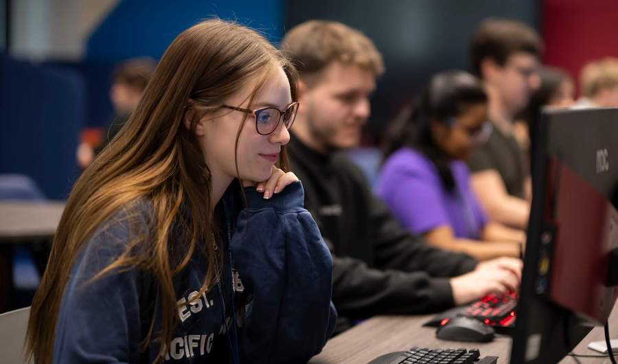 A person wearing glasses working at a computer.