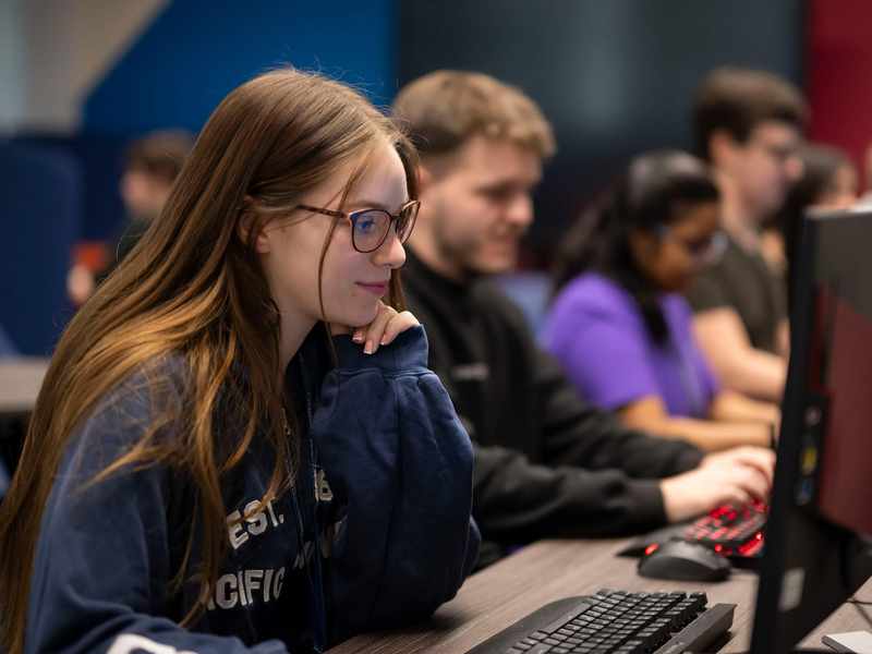 A person wearing glasses working at a computer.