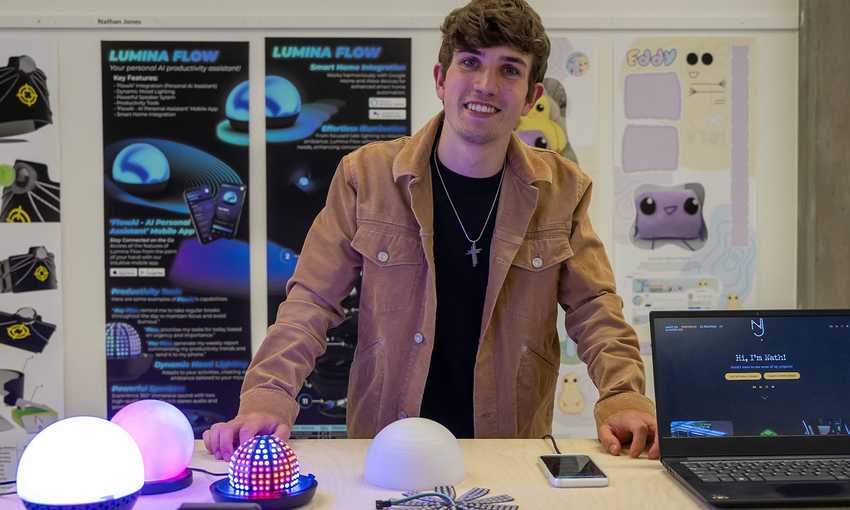 A man is positioned before a laptop and a lamp, engaged in his tasks in a bright setting.