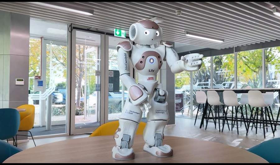 Humanoid robot stands on a wooden table
