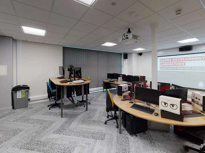 Computer desks in front of projector in office room.