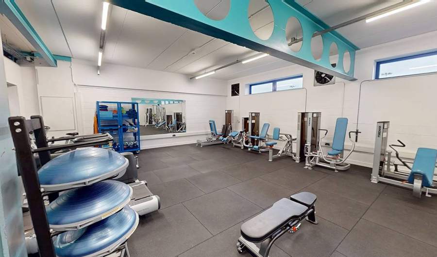 A gym with various weights and exercise equipment.