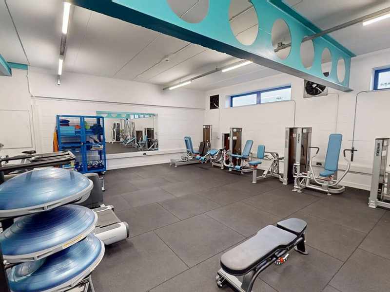 A gym with various weights and exercise equipment.