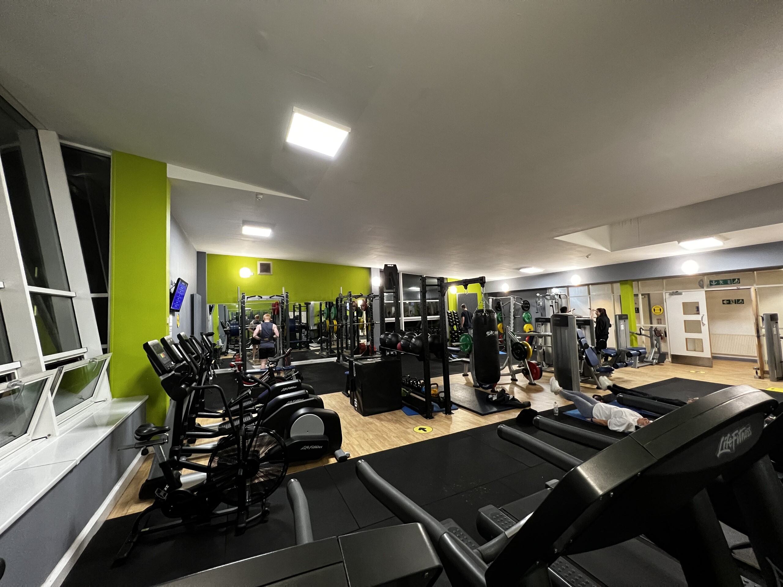 Several people working on various exercise machines in a gymnasium