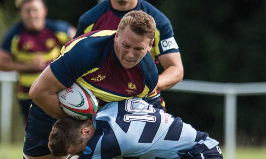 Alex Dombrandt gets tackled around the waist during a game of rugby