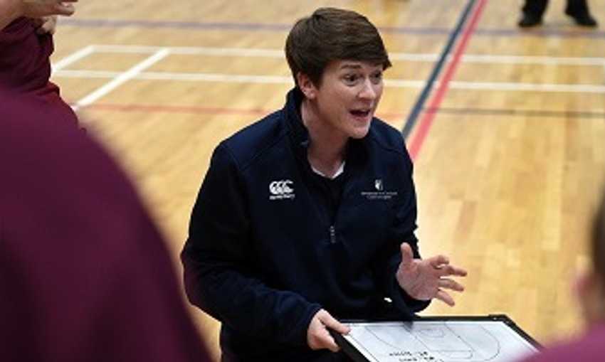 Team coach discusses sports tactics while holding a small whiteboard