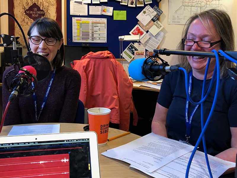 Lecturers sat in front of microphones at a round table in discussion