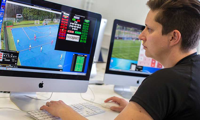 A student analyzes sports footage on an iMac, reviewing match data and player statistics.
