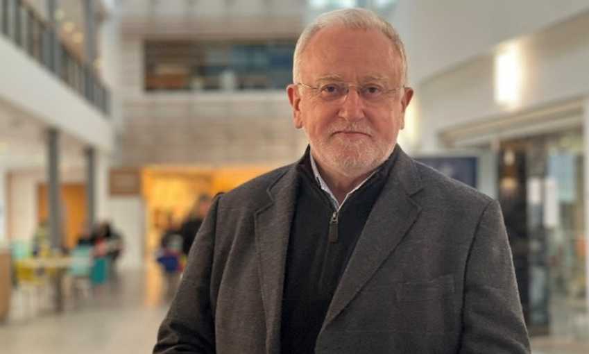 Headshot of Stephen Forster standing in the atrium of the School of Management building