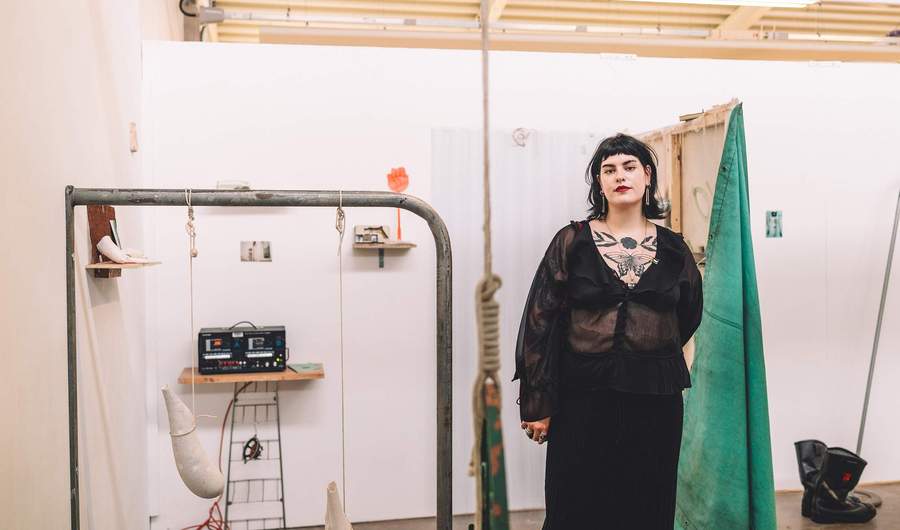 A person stands in front of an art installation.