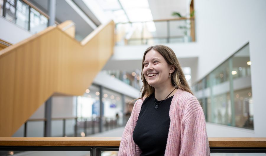 Heather Blackmore leans on the balcony of a mezzanine overlooking the Cardiff School of Management ground floor