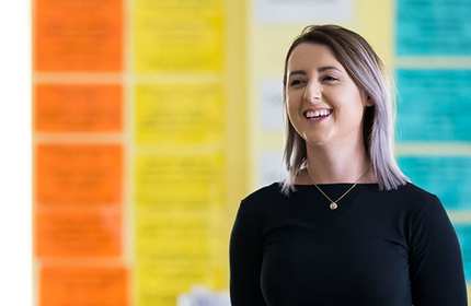 Headshot of smiling student in front of colourful background