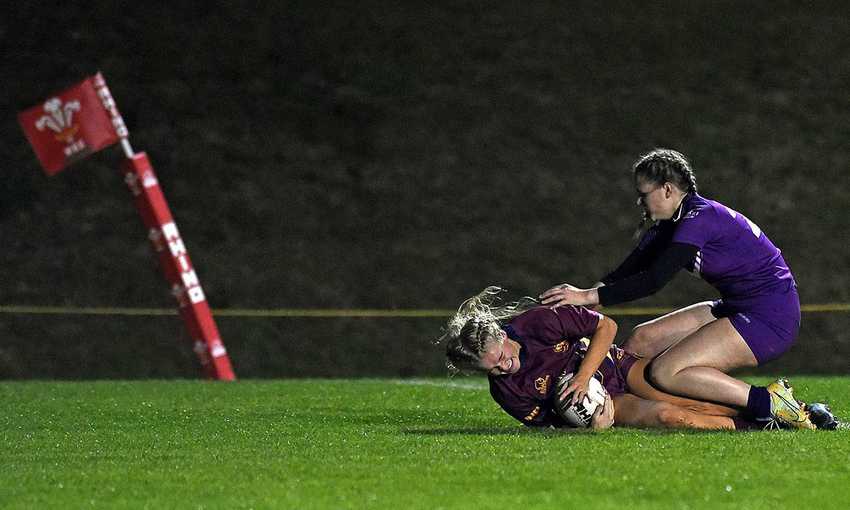 Two women compete for the rugby ball during a game