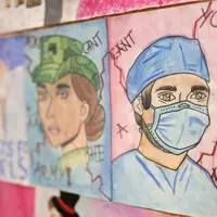 A wall displaying various pictures of individuals wearing masks in different styles and colors.